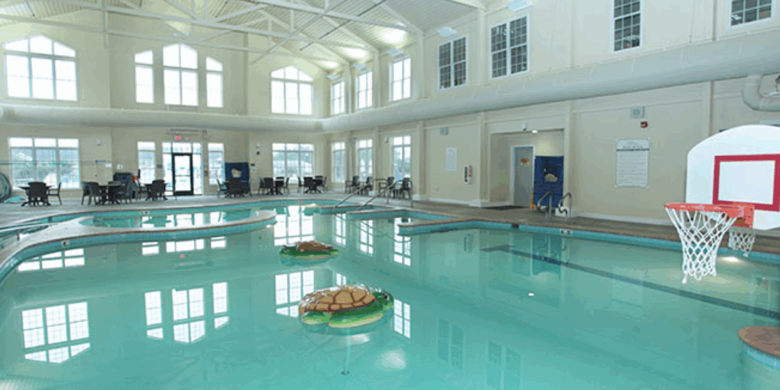 A large indoor swimming pool with two floating trays of food.