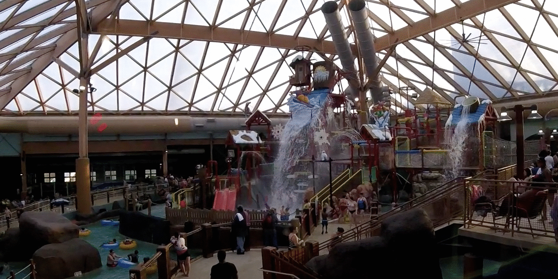 A large indoor water park with many people.